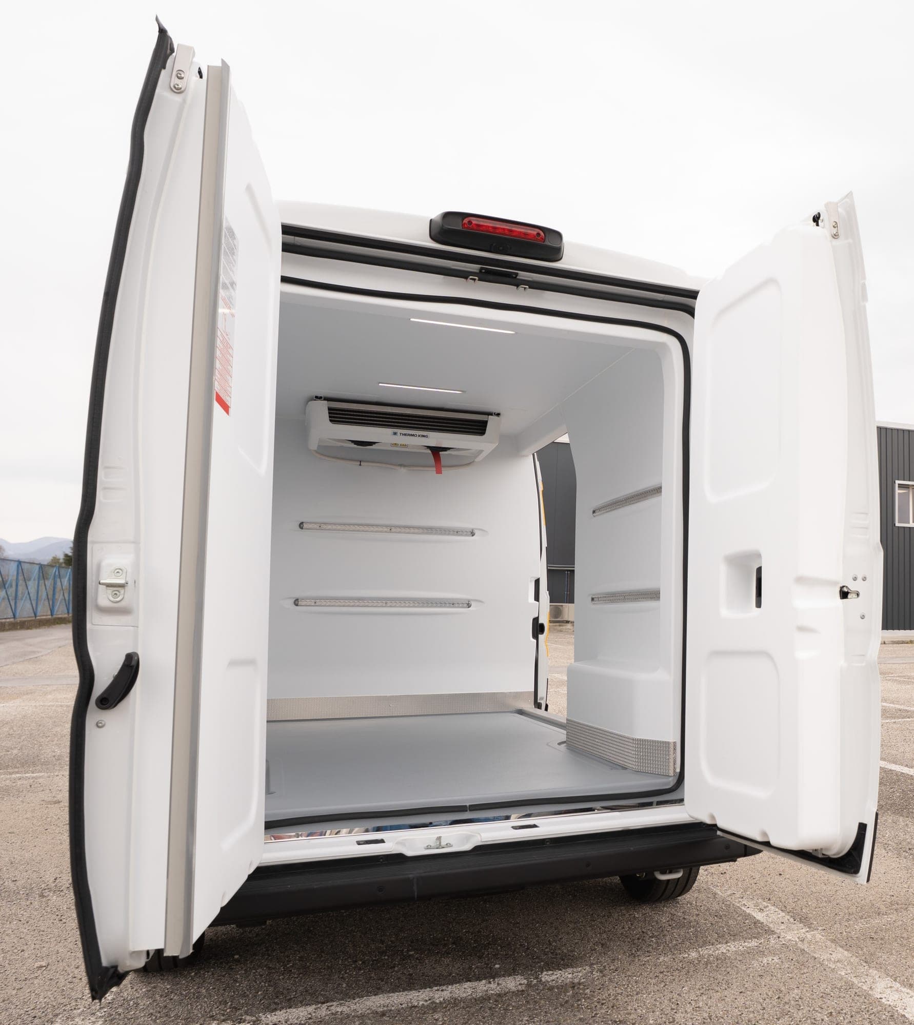 Otwarte drzwi przestrzeni Fiat Ducato z wykładziną z termoformowanego ABS i podłogą antypoślizgową.