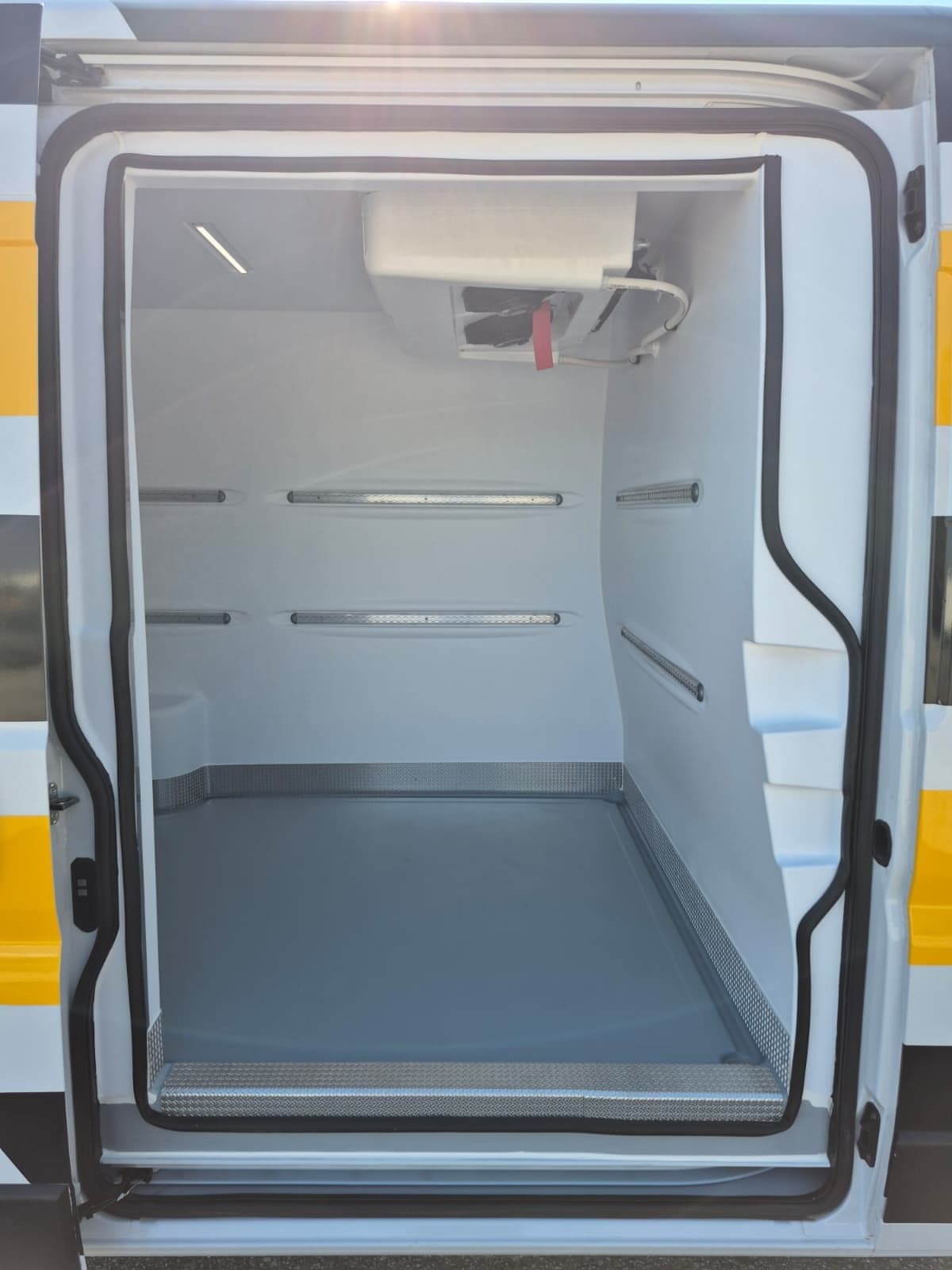 Otwarte drzwi przestrzeni Fiat Ducato z wykładziną z termoformowanego ABS i podłogą antypoślizgową.