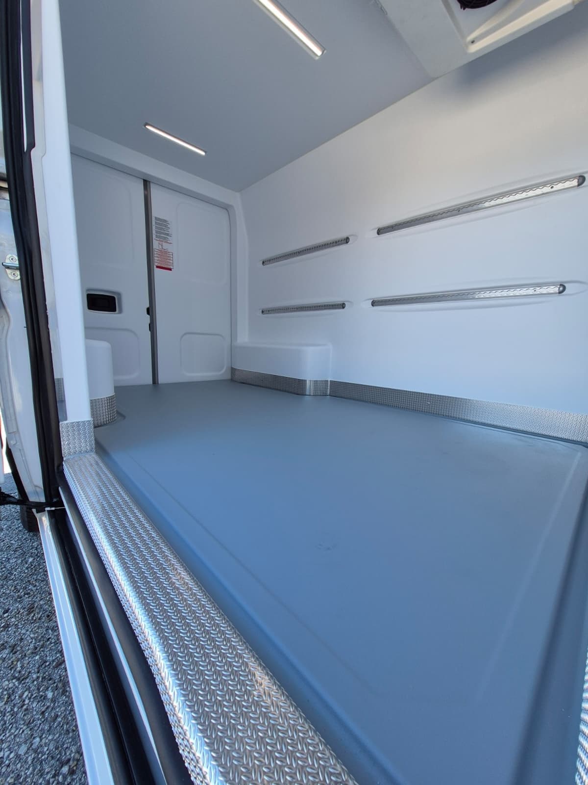 Próg z ryflowanego aluminium i szara podłoga ABS antypoślizgowa w izotermicznej przestrzeni Ducato.