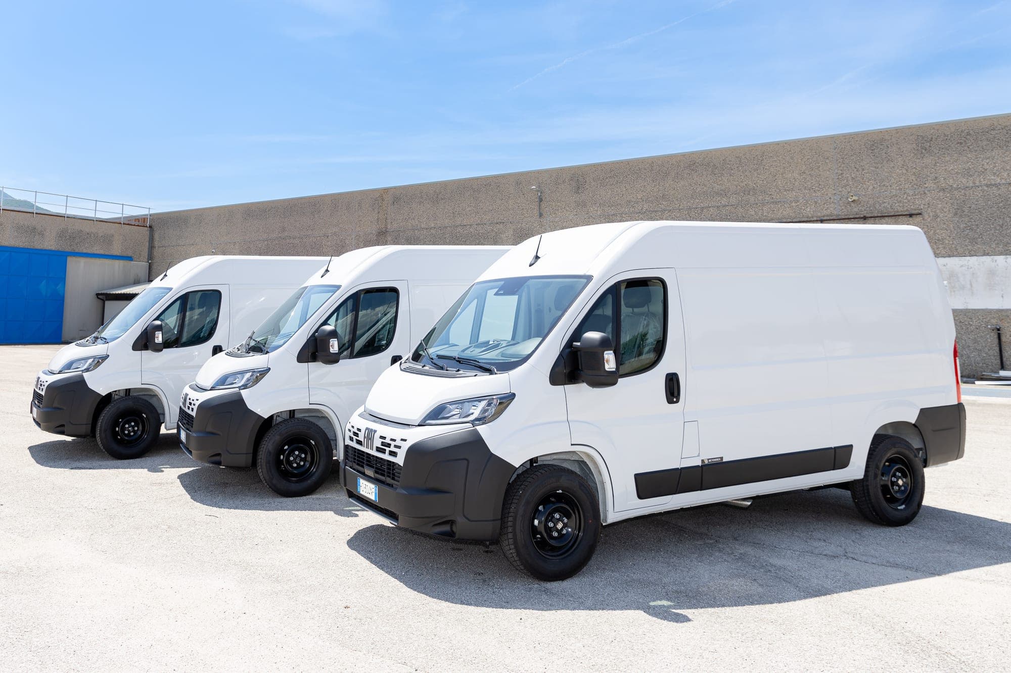 Samochody Fiat Ducato ustawione przed zakładem produkcyjnym Beyonder.