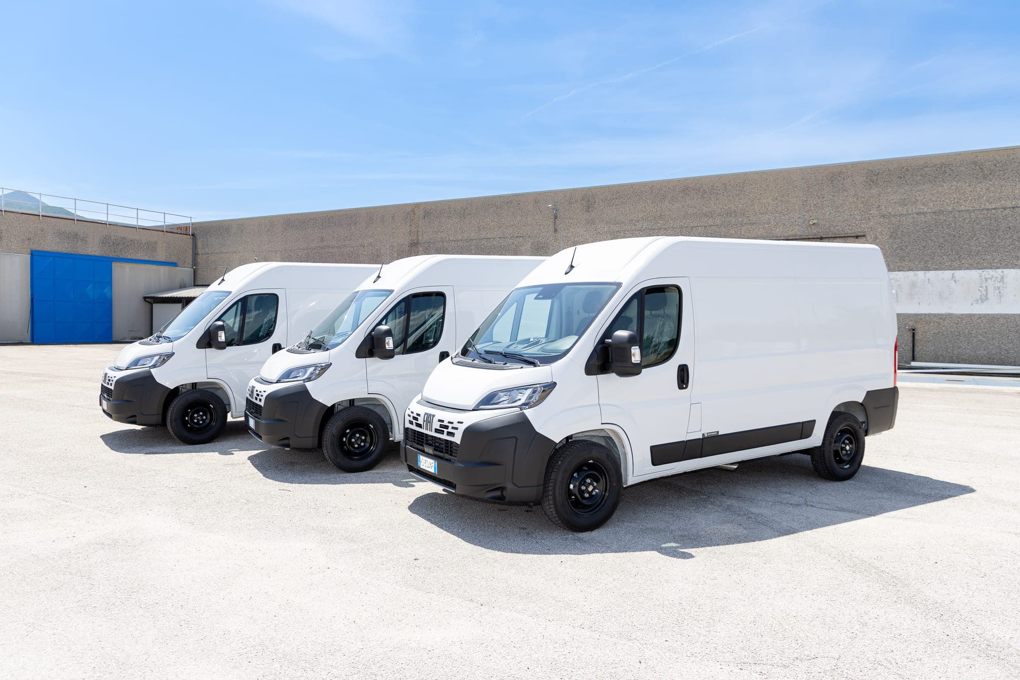 Samochody Fiat Ducato ustawione przed zakładem produkcyjnym Beyonder.