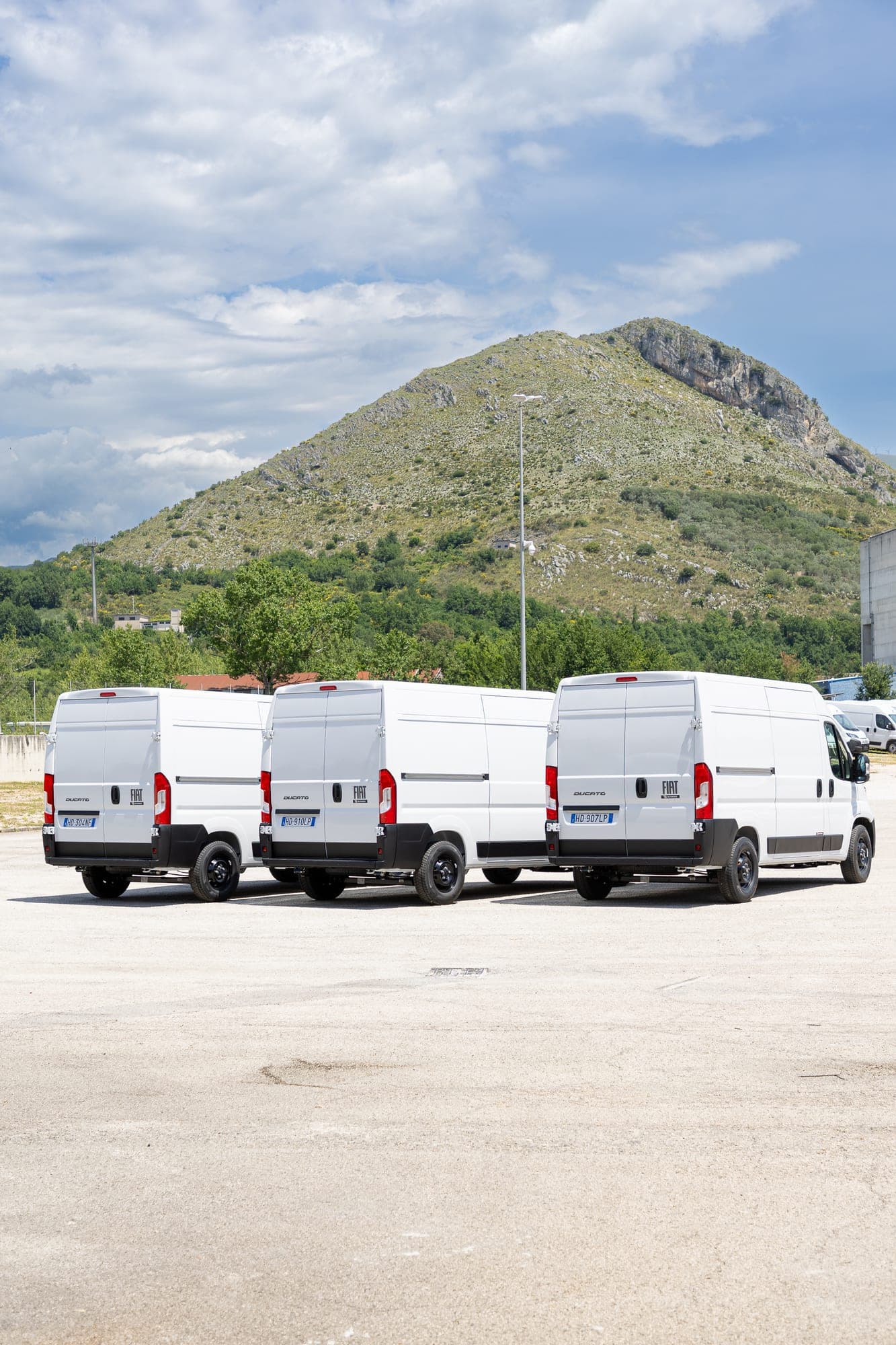 Samochody Fiat Ducato ustawione przed zakładem produkcyjnym Beyonder.