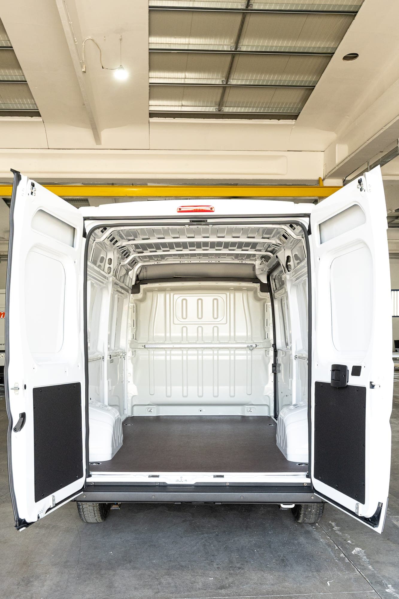 Otwarte drzwi przestrzeni Fiat Ducato z wykładziną z termoformowanego ABS i podłogą antypoślizgową.