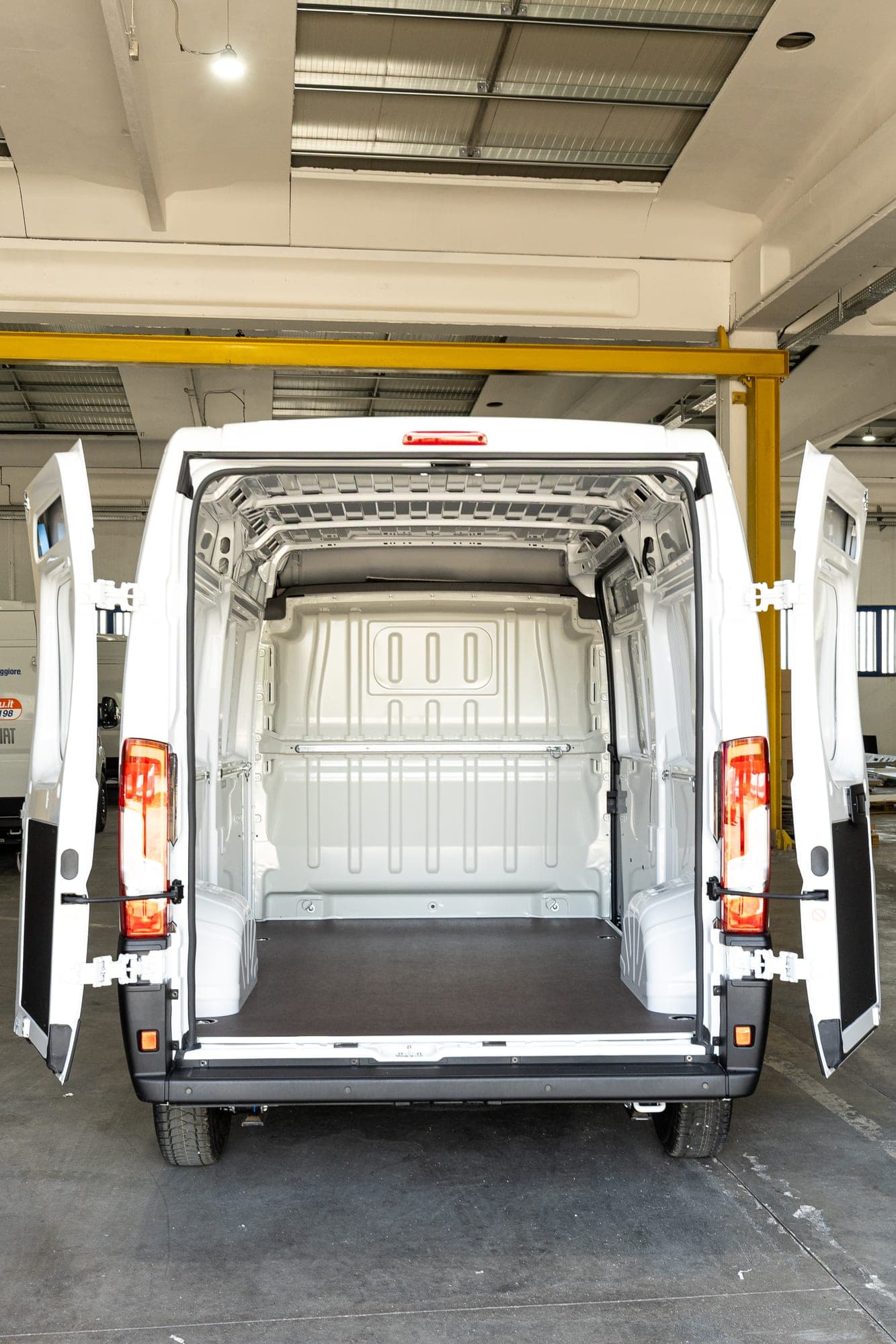 Otwarte drzwi przestrzeni Fiat Ducato z wykładziną z termoformowanego ABS i podłogą antypoślizgową.